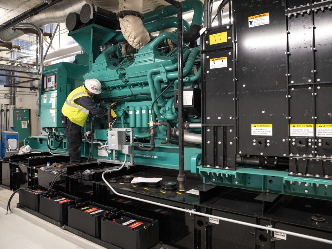 A field technician inspecting generator equipment